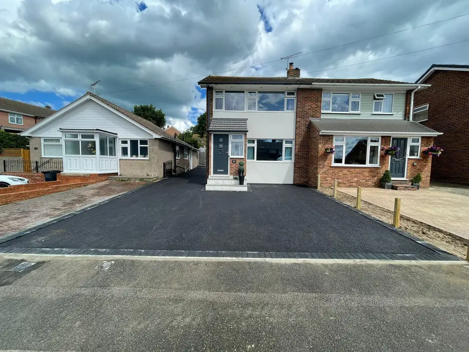 Existing dark driveway surfaces across the frontage of neighbouring homes