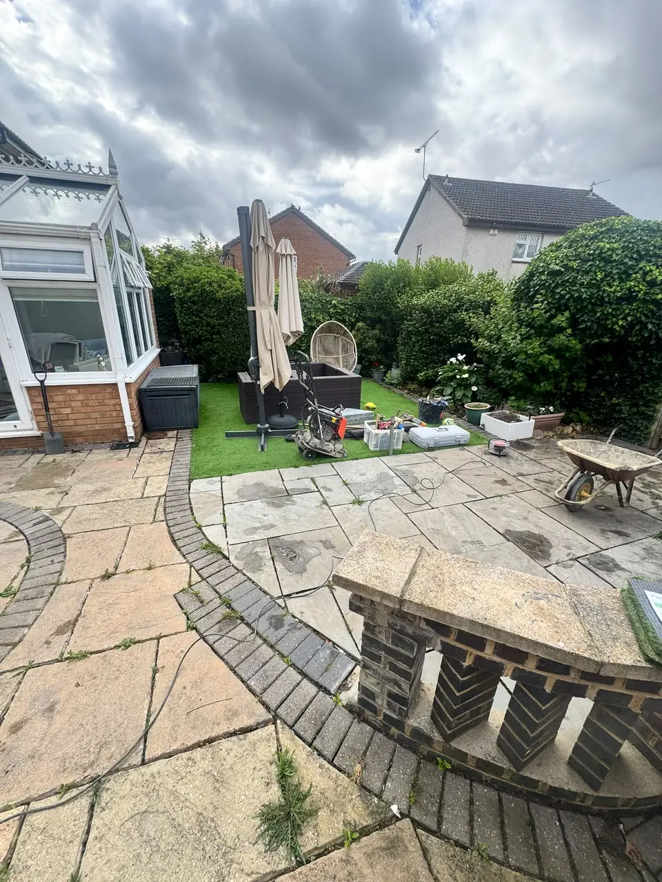 Existing paved patio and curved lawn edging before the surface work