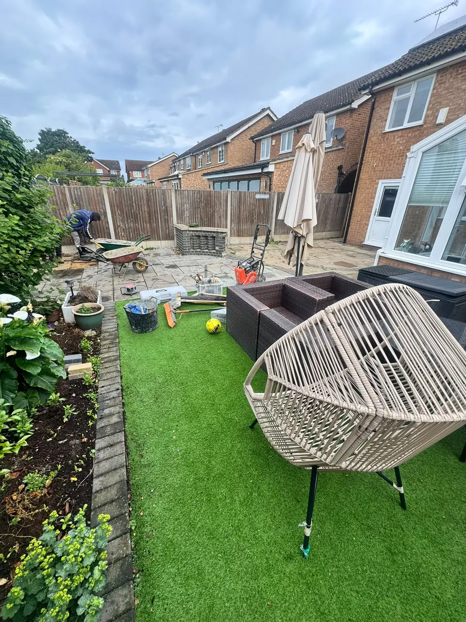 Garden and paved area during resin-bound surface work, with tools and materials on site