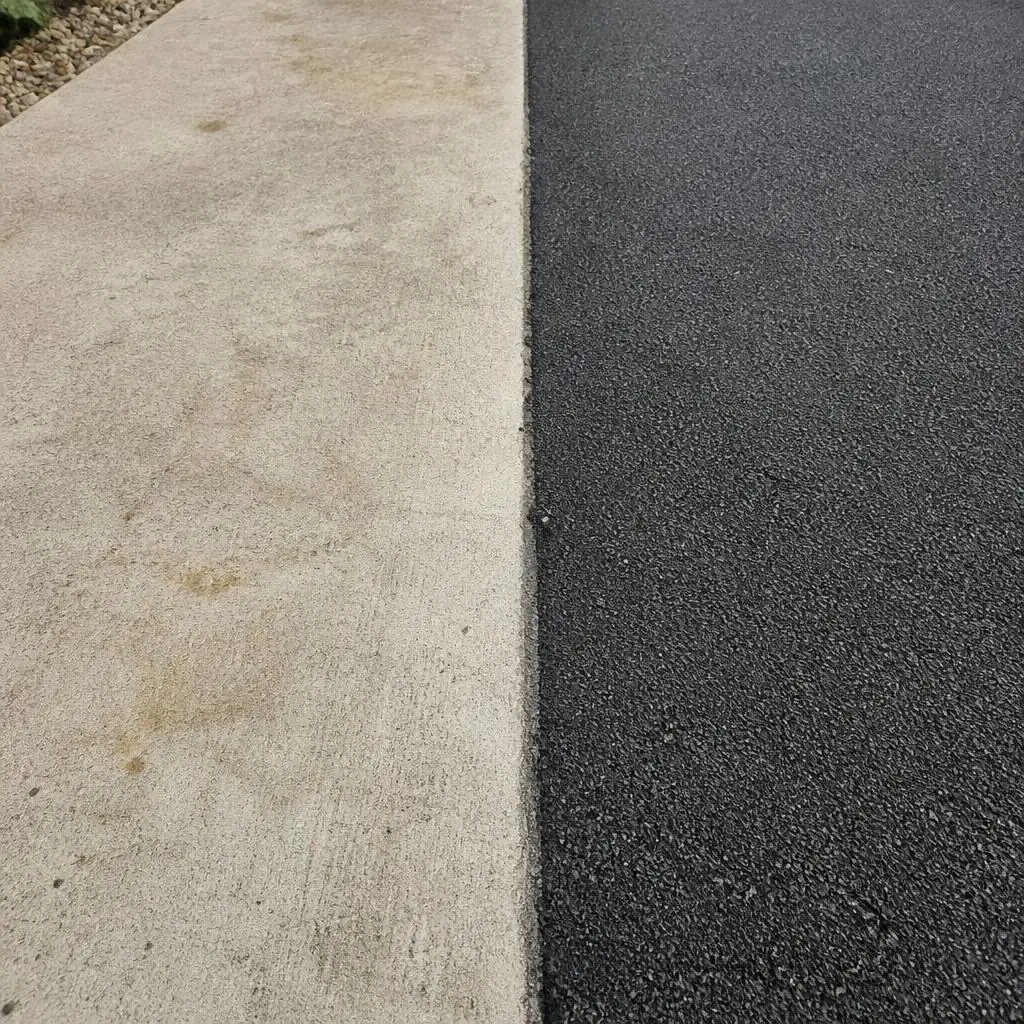 Pale concrete and dark tarmac surfaces meet at a straight edge