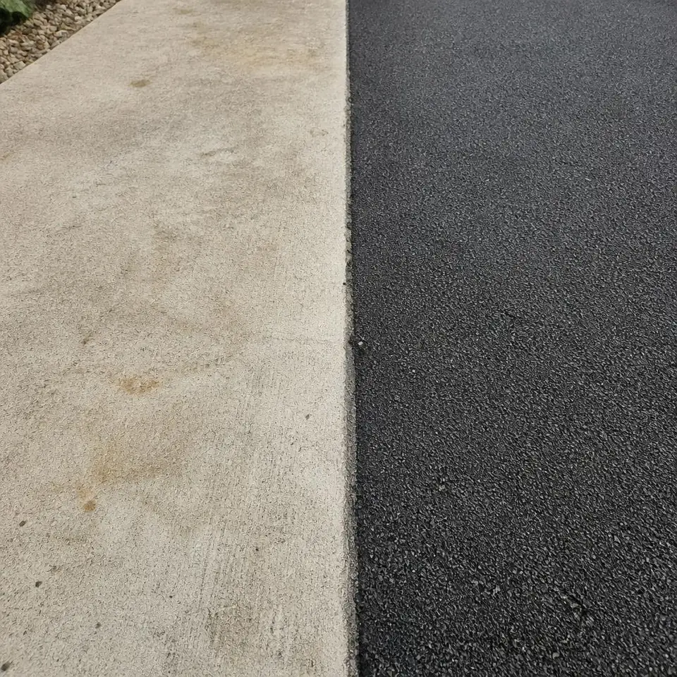 Pale concrete and dark tarmac surfaces meet at a straight edge