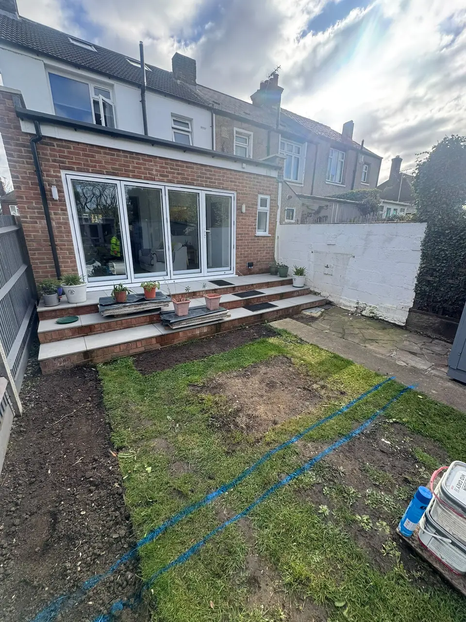 Existing garden with paved steps and areas of lawn before the patio work
