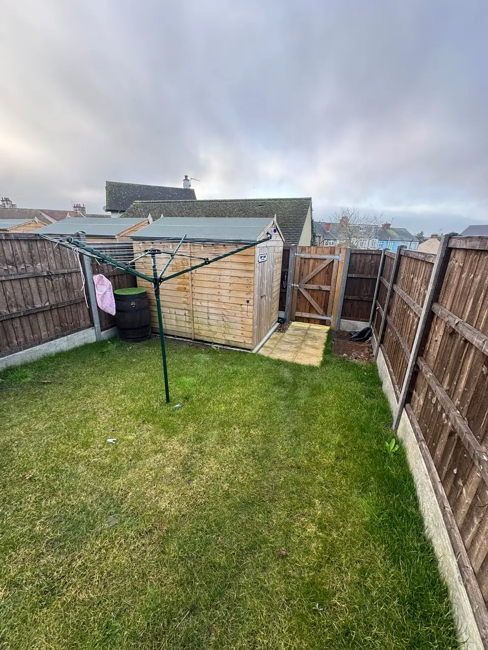 Grassed garden and timber shed before the porcelain patio installation