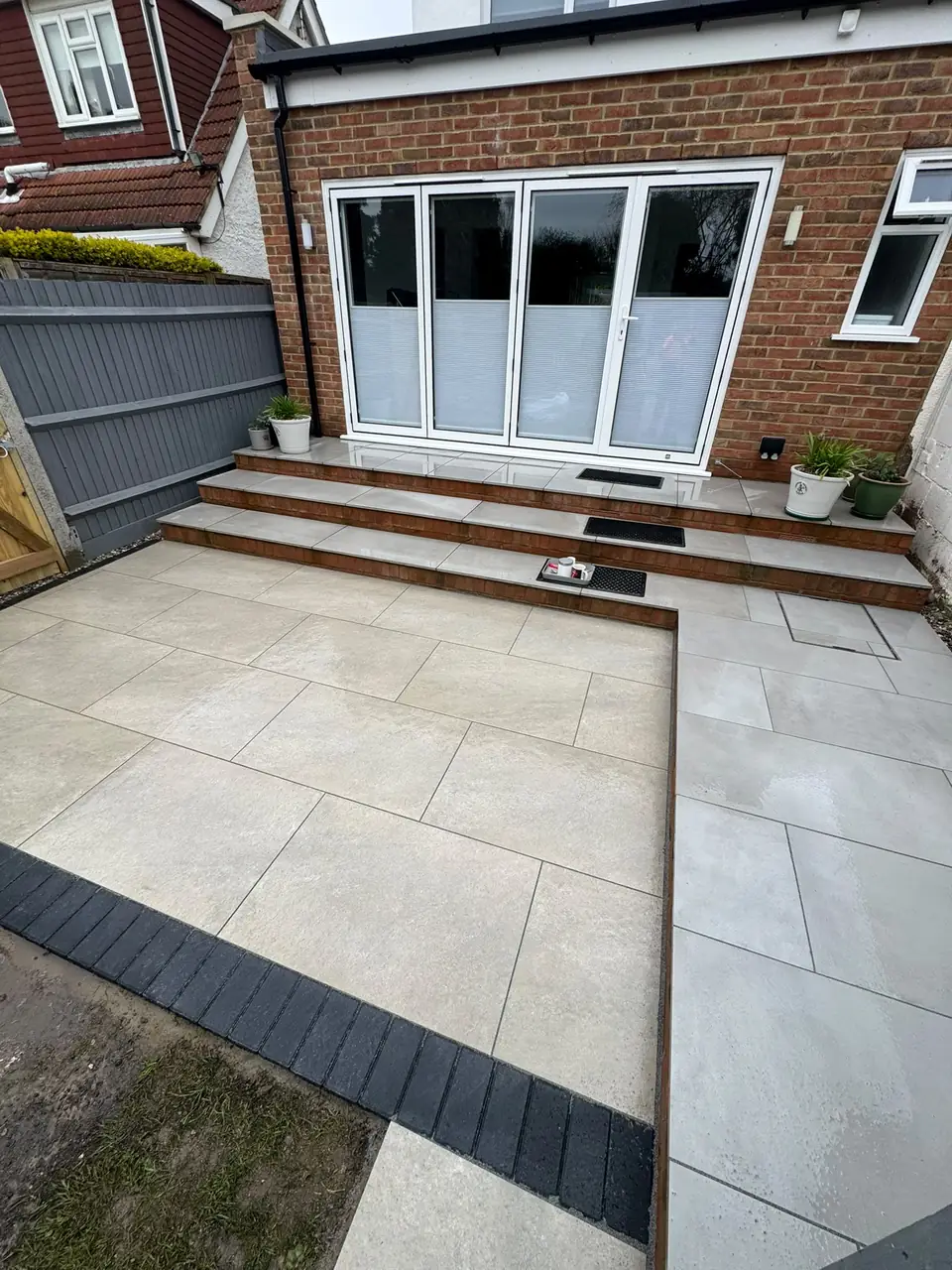 Close view of porcelain patio paving and contrasting edging around garden steps