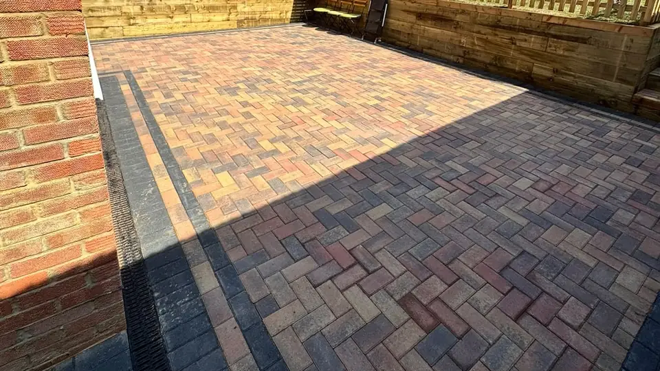 Completed garden patio with coloured paving and dark edging