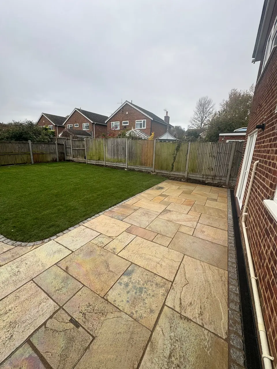 Natural stone garden paving beside a planted border
